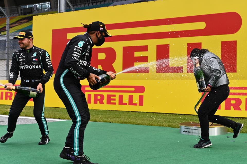 Mercedes' British driver Lewis Hamilton and Mercedes' Finnish driver Valtteri Bottas (L) celebrate with champagne after the Formula One Styrian Grand Prix race on July 12, 2020 in Spielberg, Austria. (Photo by Joe Klamar / various sources / AFP) (Photo by JOE KLAMAR/AFP via Getty Images)