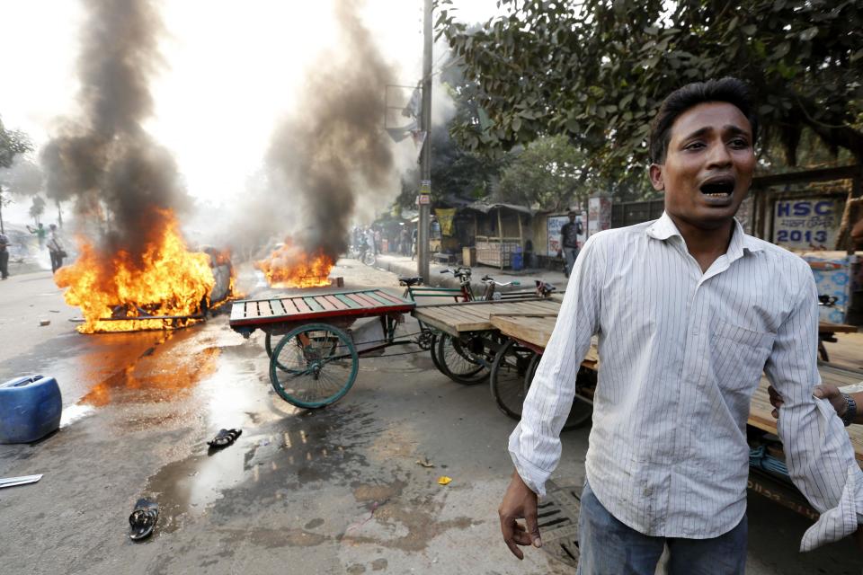 A man cries after Jamaat-e-Islami party activists torched his vehicle during a clash with police in Dhaka