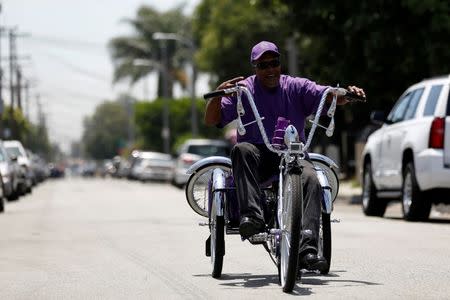 William Holloway rides his customized Los Angeles Lakers inspired low rider bicycle outside Manny's bike shop in Compton, California U.S., June 3, 2016. Picture taken June 3, 2016. REUTERS/Mario Anzuoni