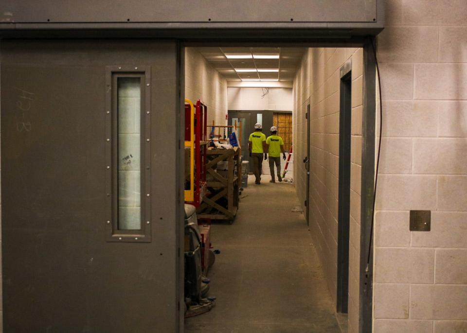 Turner Construction workers walk down a hallway toward one of the cell blocks at the Saline County Jail. The jail is set for substantial completion later this month.