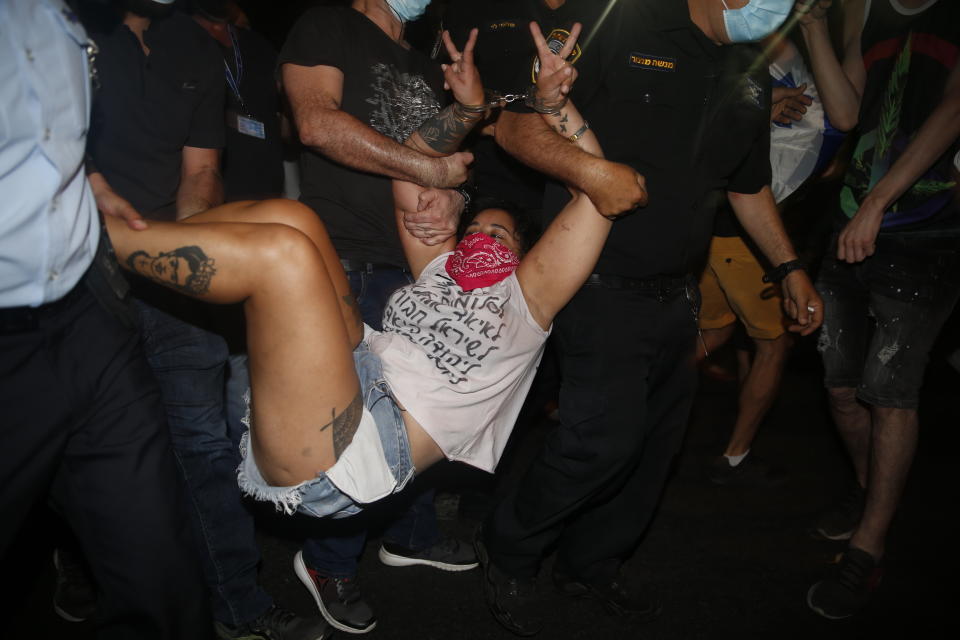 Israeli police officers arrest an Israeli protester during a demonstration against lockdown measures that they believe are aimed at curbing protests against prime minister Benjamin Netanyahu Tel Aviv, Israel, Saturday, Oct. 3, 2020. (AP Photo/Ariel Schalit)