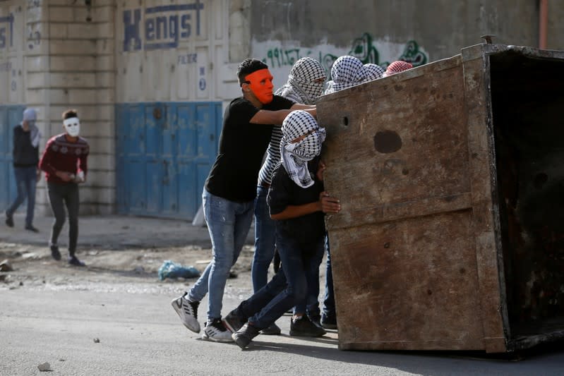 Palestinian demonstrators set up a barricade during an anti-Israel protest in al-Arroub refugee camp, in the Israeli-occupied West Bank