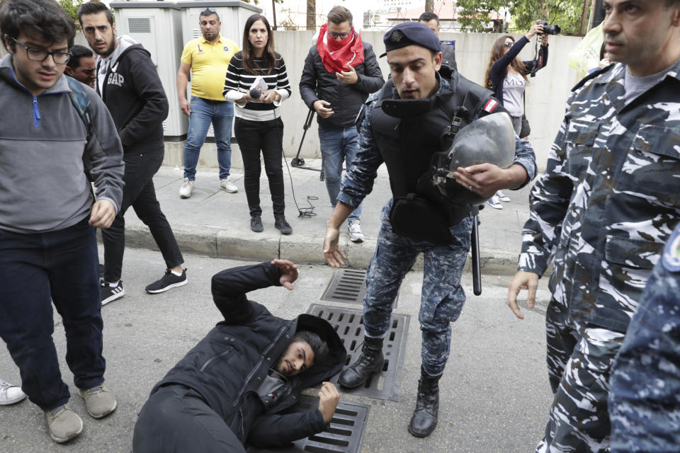 Riot police scuffle with anti-government protesters blocking a road in Beirut, Lebanon, Monday, Nov. 25, 2019. A key road has reopened in the Lebanese capital following clashes throughout the night between rival groups. (AP Photo/Hassan Ammar)