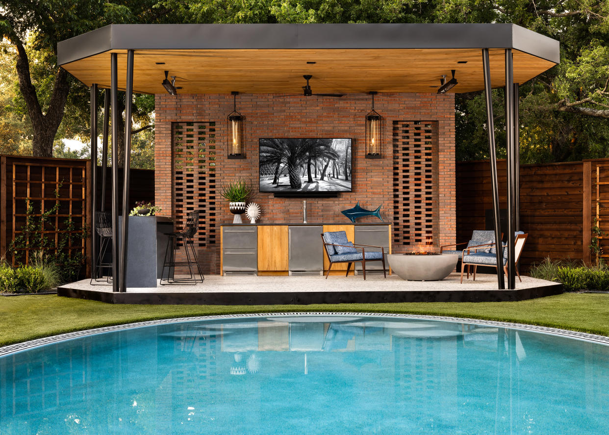  An outdoor kitchen and seating area under a canopy. 