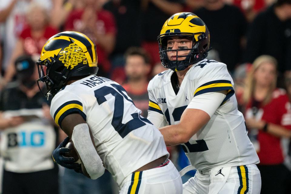 Michigan Wolverines quarterback Cade McNamara hands off the ball to running back Hassan Haskins during the first quarter against the Nebraska Cornhuskers at Memorial Stadium.