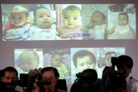 FILE PHOTO: Surrogate babies that Thai police suspect were fathered by a Japanese businessman who has fled from Thailand are shown on a screen during a news conference at the headquarters of the Royal Thai Police in Bangkok August 12, 2014. REUTERS/Athit Perawongmetha/File Photo