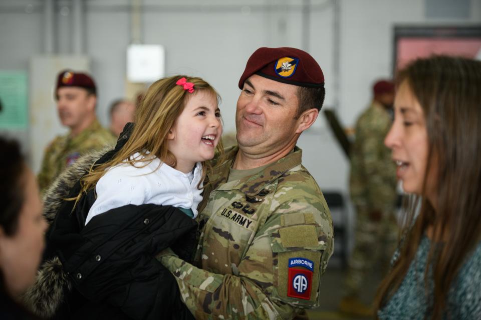 Lt. Col. Eric Glassman plays with his daughter as his wife, Cathy, right, talks to a reporter at the conclusion of the 82nd Combat Aviation Brigade color casing ceremony on Friday, Dec. 1, 2023.