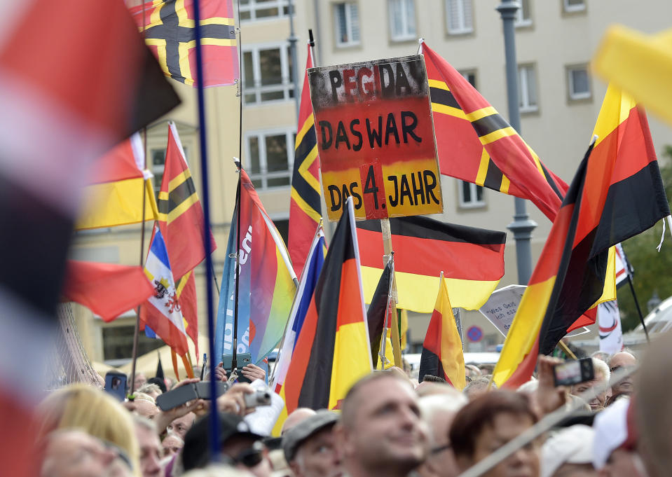 People carry a sign reading "PEGIDA that was your fourth year" during a rally of PEGIDA (Patriotic Europeans against the Islamization of the West) in Dresden, Germany, Sunday, Oct.21, 2018. (AP Photo/Jens Meyer)