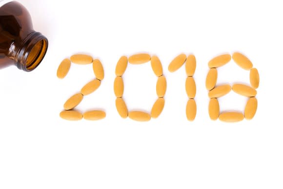 The number 2018 formed with pills, with a brown pill bottle in the corner.