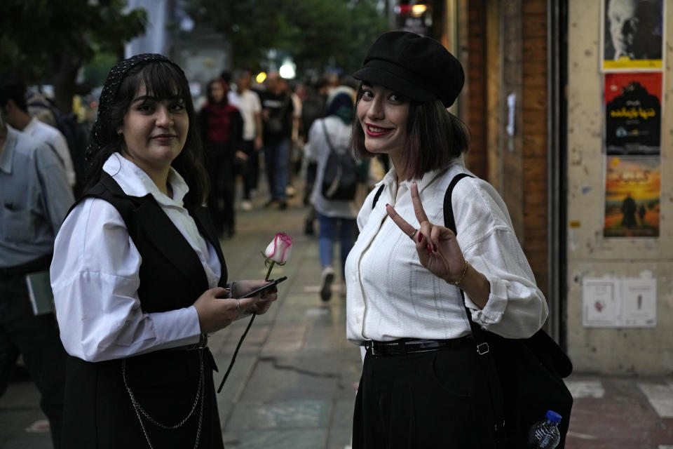 An Iranian woman without wearing her mandatory Islamic headscarf flashes a victory sign as she walks in downtown Tehran, Iran, Monday, June 10, 2024. (AP Photo/Vahid Salemi)