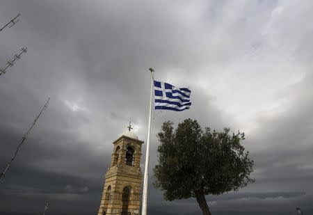 A Greek flag flutters between Saint George's bell tower and an olive tree atop the Lycabettus hill March 6, 2015. REUTERS/Yannis Behrakis