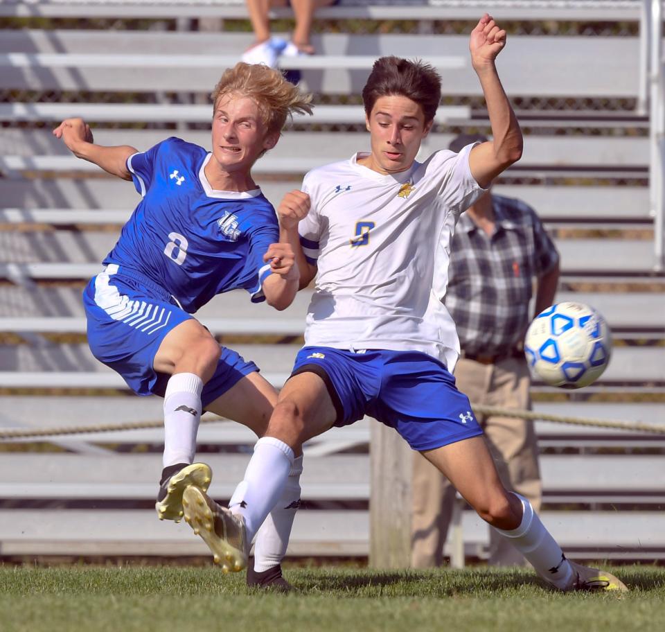 Jadon Barton of Upper Cape (left) kicks the ball past Ethan Potito of Wareham.