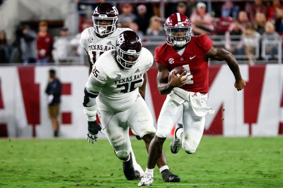 Alabama quarterback Jalen Milroe (4) scrambles away from Texas A&M defensive lineman McKinnley Jackson (35) during the first half at Bryant-Denny Stadium.