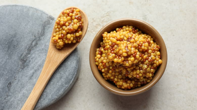 A spoon and bowl of whole grain mustard