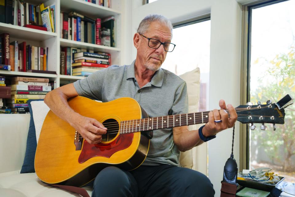 Bruce Arlen plays guitar in his home on Aug. 5, 2022, in Cave Creek.