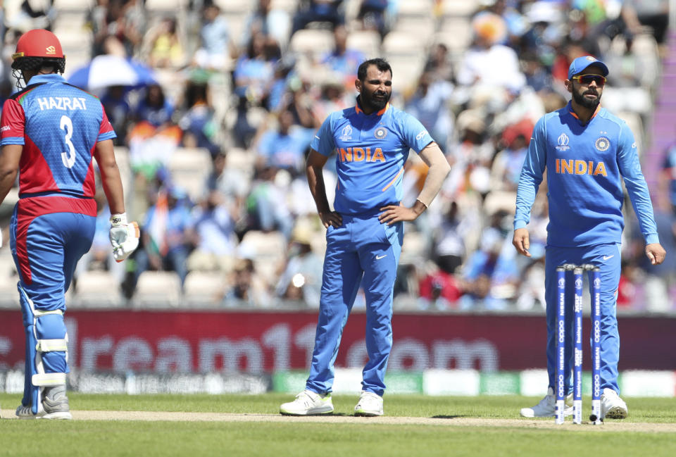 India's Mohammed Shami, center, and captain Virat Kohli, right, listen to wicketkeeper MS Dhoni before asking for a review for the wicket of Afghanistan's Hazratullah Zazai, left, during the Cricket World Cup match between India and Afghanistan at the Hampshire Bowl in Southampton, England, Saturday, June 22, 2019. (AP Photo/Aijaz Rahi)