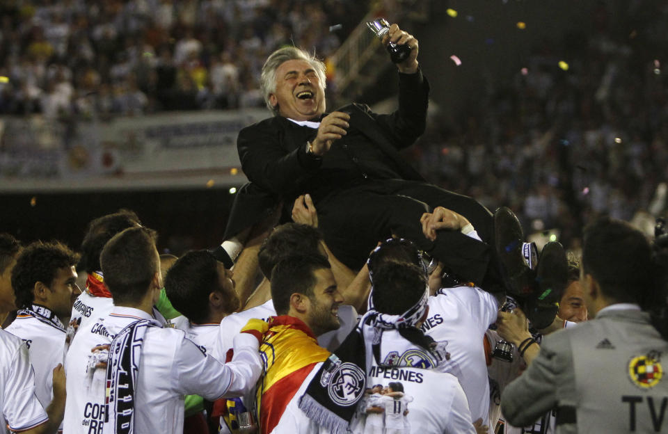 Real's coach Carlo Ancelotti is lifted by team players after Real Madrid won the final of the Copa del Rey between FC Barcelona and Real Madrid at the Mestalla stadium in Valencia, Spain, Wednesday, April 16, 2014. (AP Photo/Alberto Saiz)