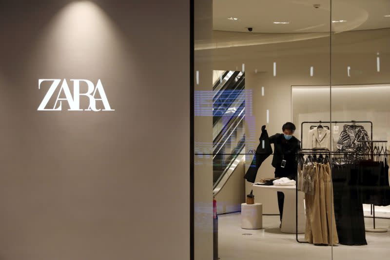 FILE PHOTO: A staff member sorts clothes inside a clothing store at a newly opened shopping mall in Beijing, China