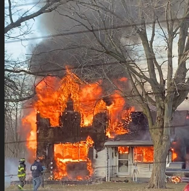 Fire crews work to extinguish a house fire Tuesday along N Drive South in Clarendon Township.