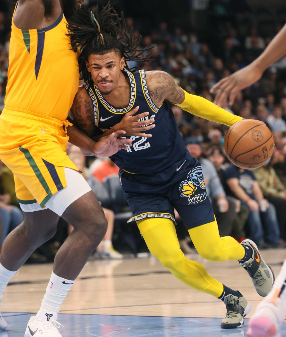 Memphis Grizzlies guard Ja Morant drives into the lane past Utah Jazz forward Eric Paschall at FedExForum on Friday, Jan. 28, 2022. 