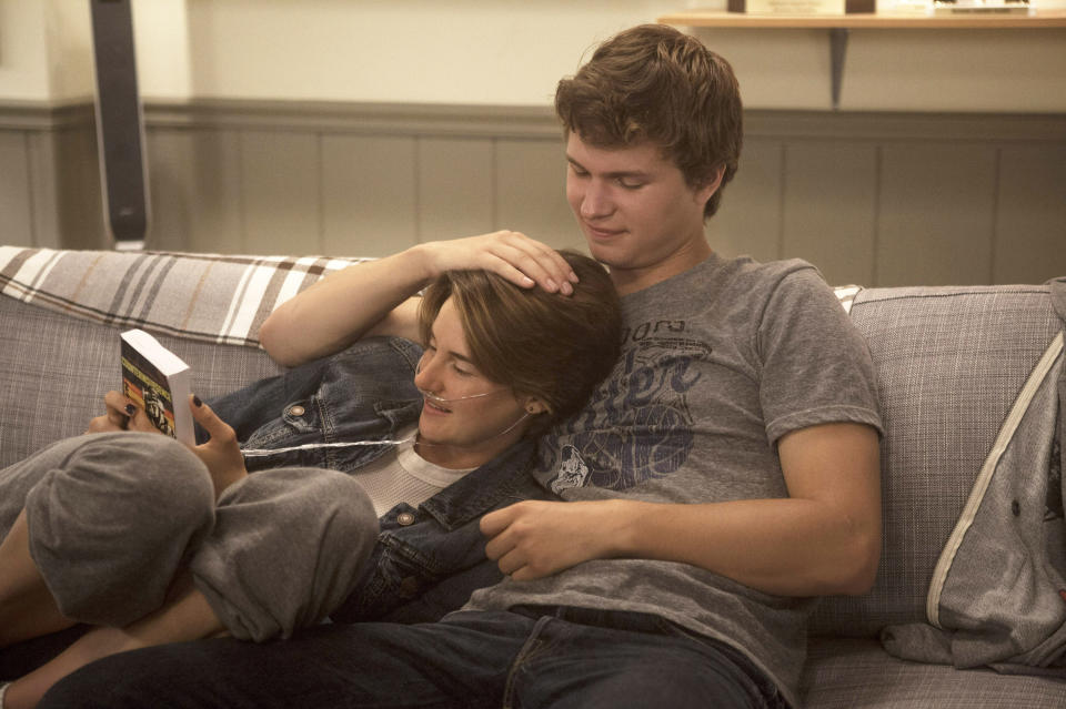Shailene Woodley looking at a book while cuddling with Ansel Elgort