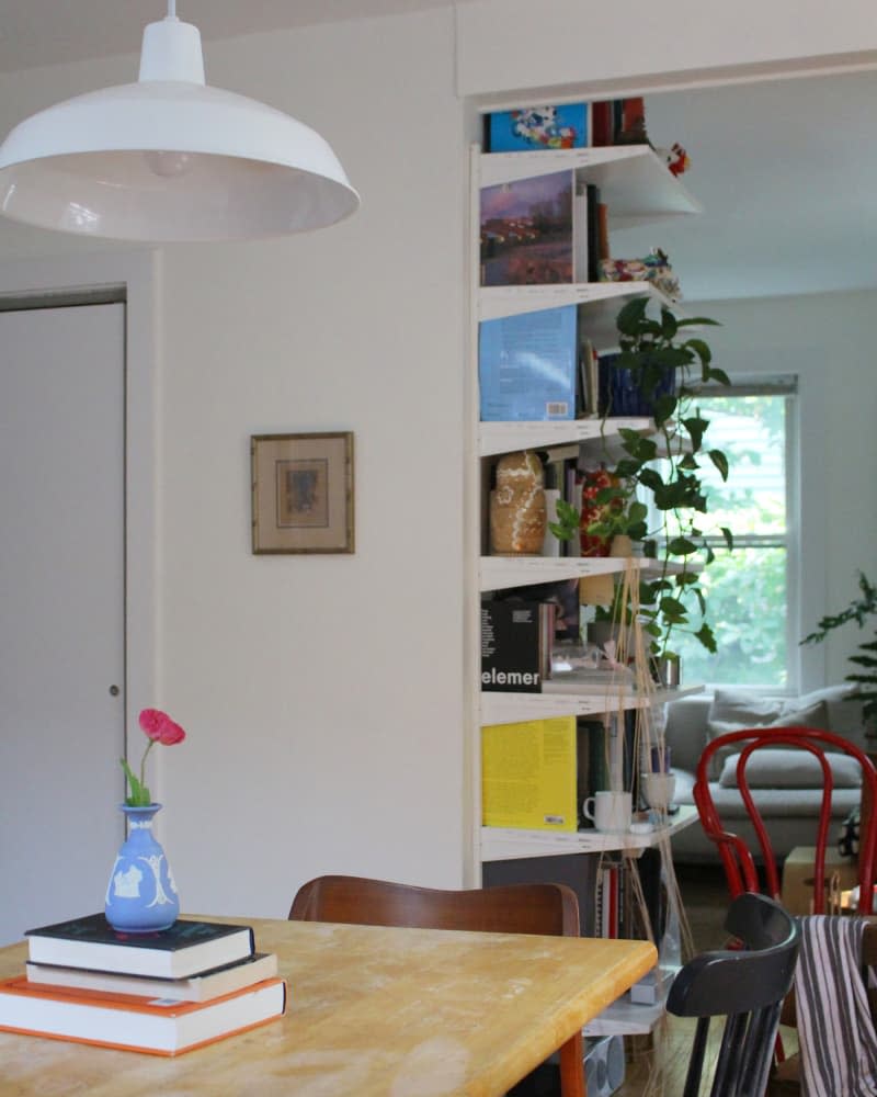 Pendant light hung over dining room table surrounded by mix-matched chairs.