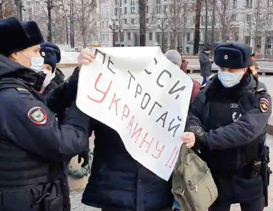一名男子在俄羅斯舉旗呼籲勿對烏克蘭開戰，遭警方帶走。   圖：翻攝自推特