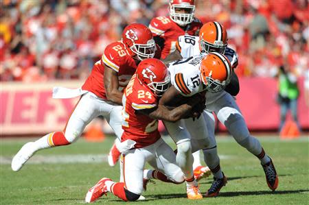 Cleveland Browns wide receiver Josh Gordon (12) is tackled by Kansas City Chiefs cornerback Brandon Flowers (24) and strong safety Eric Berry (29) during the second half at Arrowhead Stadium. The Chiefs won 23-17. Mandatory Credit: Denny Medley-USA TODAY Sports
