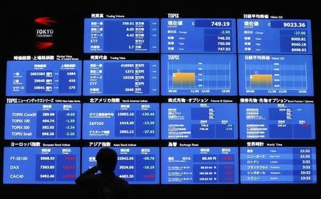 A visitor looks at a screen displayed market indices from around the world and foreign currency rates against the Japanese yen at the Tokyo Stock Exchange in Tokyo November 5, 2012. REUTERS/Issei Kato