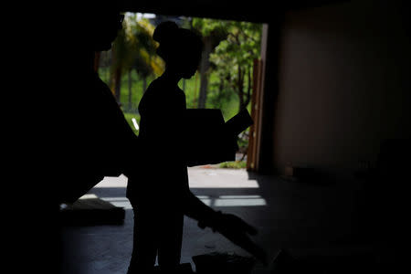 A volunteer is seen in silhouette preparing donations to be delivered to the people affected by Hurricane Maria in the Trujillo Alto municipality outside of San Juan, Puerto Rico, October 9, 2017. REUTERS/Shannon Stapleton
