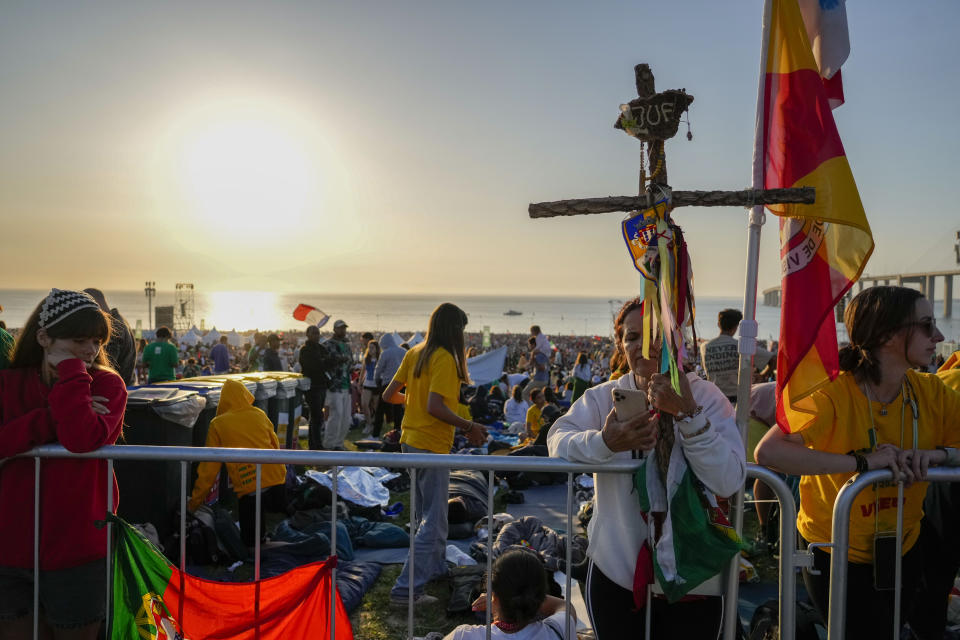Pilgrims wake up after sleeping at the Parque Tejo in Lisbon where Pope Francis will preside over a mass celebrating the 37th World Youth Day, Sunday, Aug. 6, 2023. An estimated 1.5 million young people filled the parque on Saturday for Pope Francis' World Youth Day vigil, braving scorching heat to secure a spot for the evening prayer and to camp out overnight for his final farewell Mass on Sunday morning. (AP Photo/Gregorio Borgia)