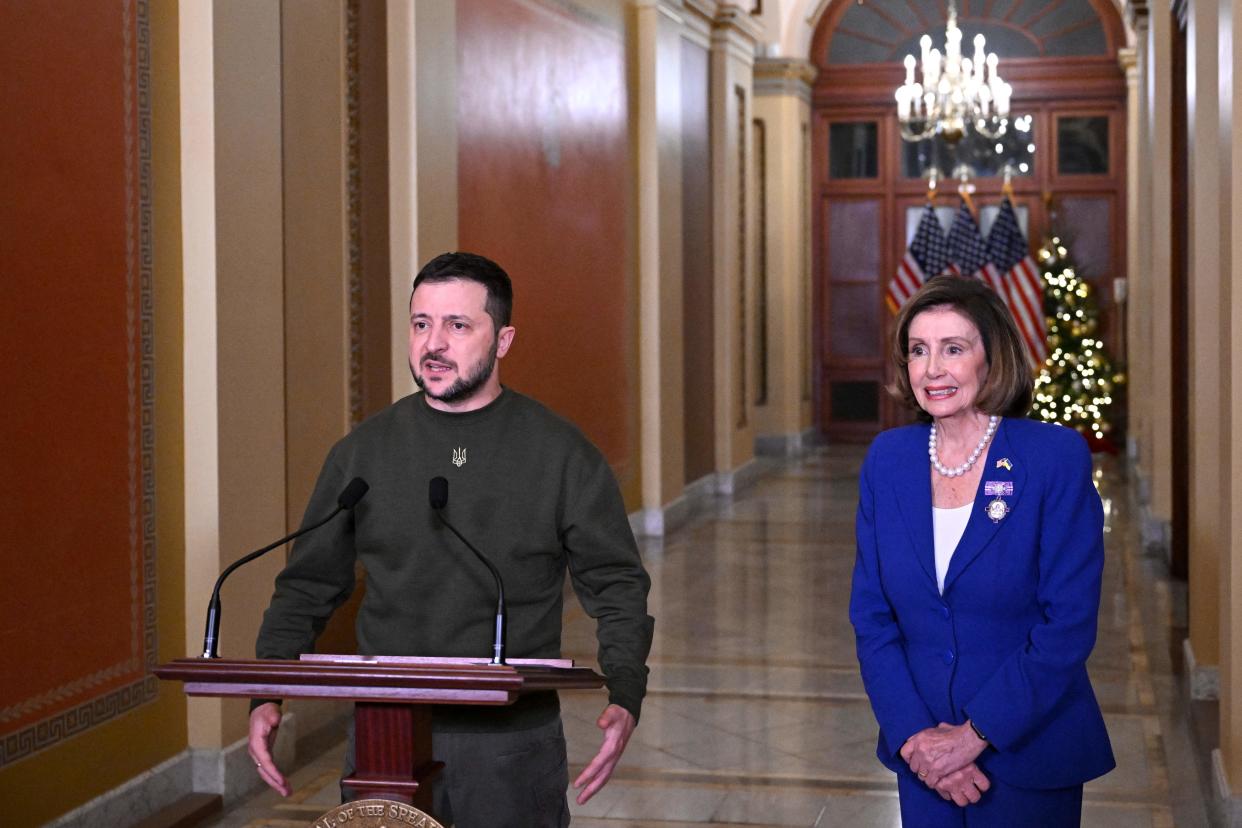 Zelensky, flanked by Pelosi, stands at a podium in a Capitol hallway.