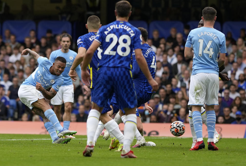 Manchester City's Gabriel Jesus, left, scores his side's opening goal during the English Premier League soccer match between Chelsea and Manchester City at Stamford Bridge Stadium in London, Saturday, Sept. 25, 2021. (AP Photo/Alastair Grant)