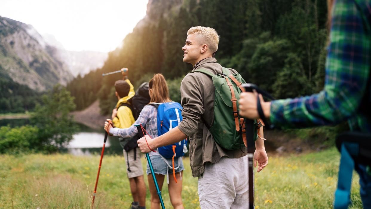 Group of hikers and friends walking on a mountain at sunset.