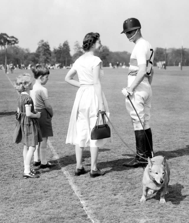 The Queen holds a corgi as the couple chats in 1956 at Windsor Great Park (PA)