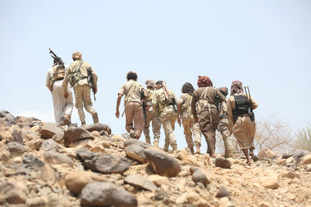 Soldiers and members of the Popular Resistance militiamen backing Yemen's President Abd-Rabbu Mansour Hadi walk as they head to the frontline of fighting against forces of Houthi rebels in Makhdara area of Marib province, Yemen June 28, 2017. Picture taken June 28, 2017. REUTERS/Ali Owidha