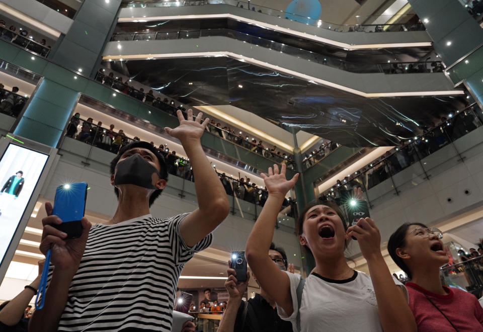 Local residents sing a theme song written by protesters "Glory be to thee" at a shopping mall in Hong Kong Wednesday, Sept. 11, 2019. Hong Kong Chief Executive Carrie Lam reassured foreign investors Wednesday that the Asian financial hub can rebound from months of protests, despite no sign that the unrest will subside. (AP Photo/Vincent Yu)