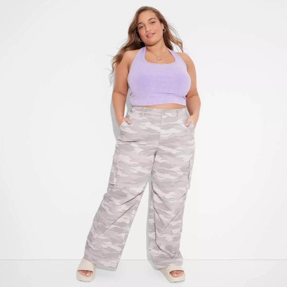 Model in a lilac tank top and camo print cargo pants