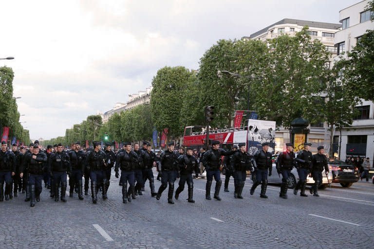 French riot police walk up the Avenue des Champs-Elysees in central Paris in May 25, 2013. Fifty opponents of gay marriage were arrested in central Paris late Saturday, police said, on the eve of a major protest against a new French law allowing homosexual couples to formally tie the knot