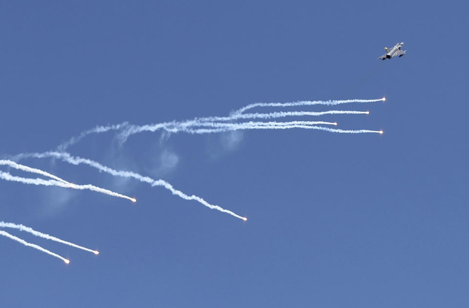 FILE - An Israeli-made fighter Kfir fighter jet releases flares during a tribute ceremony, in Bogota, Colombia, Jan. 27, 2021. (AP Photo/Fernando Vergara, File)