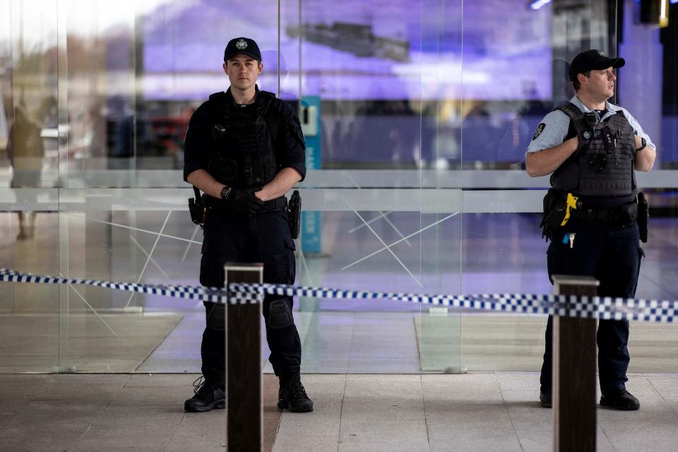 Police stand guard at the entrance of a terminal after a gunman opened fire at the airport in Canberra on August 14, 2022. - A gunman fired about five shots inside Canberra's main airport on August 14, sending passengers fleeing but injuring no-one before he was detained by Australian police. (Photo by AFP) (Photo by STR/AFP via Getty Images)