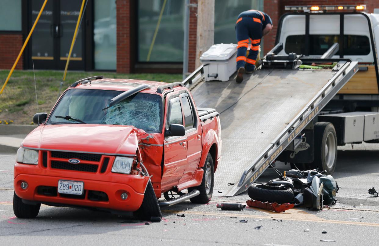 A pickup truck is towed away after being involved in a crash with a motorcycle on North Glenstone Avenue between Chestnut Expressway and St. Louis Street on Thursday, March 30, 2023.