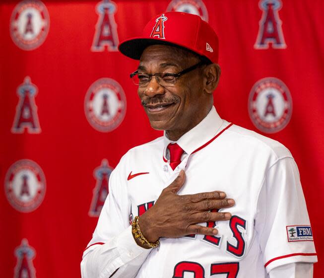 Angels new manager Ron Washington places his hand over his heart as he shows off his new Angels jersey.