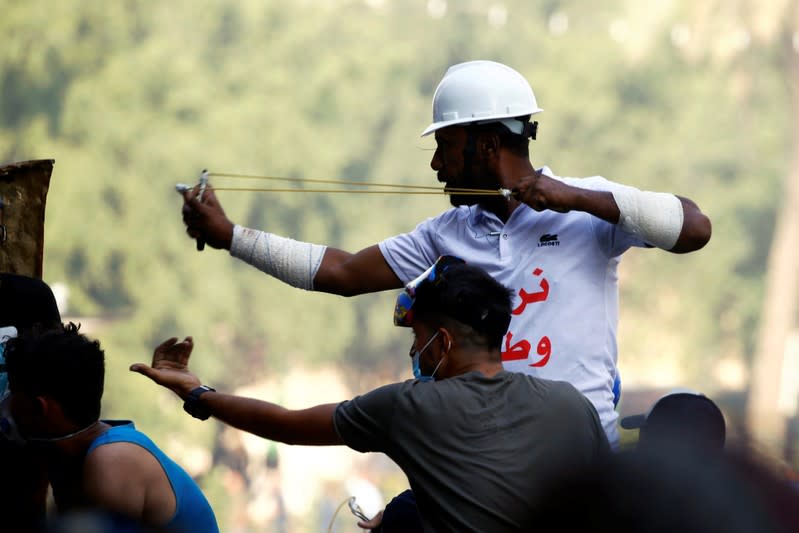 A demonstrator uses a slingshot during the ongoing anti-government protests in Baghdad