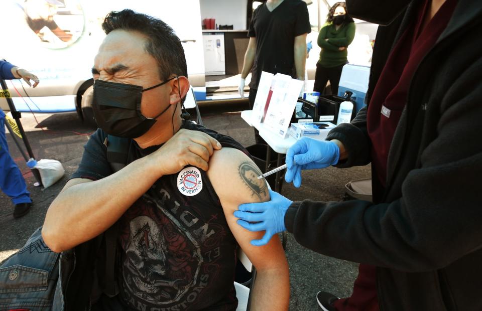 Augustine Fuentes gets the Pfizer vaccine shot from Physician Assistant-Certified Alyssa Hernandez