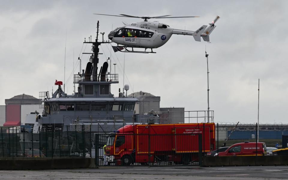 A French Urgent Medical Aid Service helicopter landing at Dunkerque port, northern France, after a boat carrying migrants capsized off the coast - DENIS CHARLET/AFP