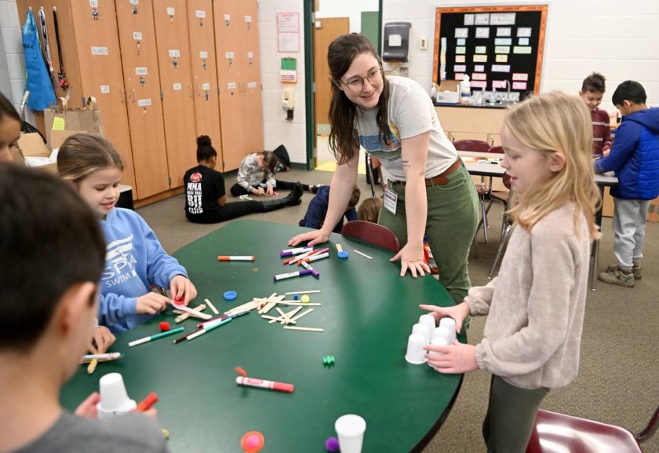 Penn State graduate student Emma Steinbebronn talks to third graders Thursday about their catapults during the STEM class at Park Forest Elementary.