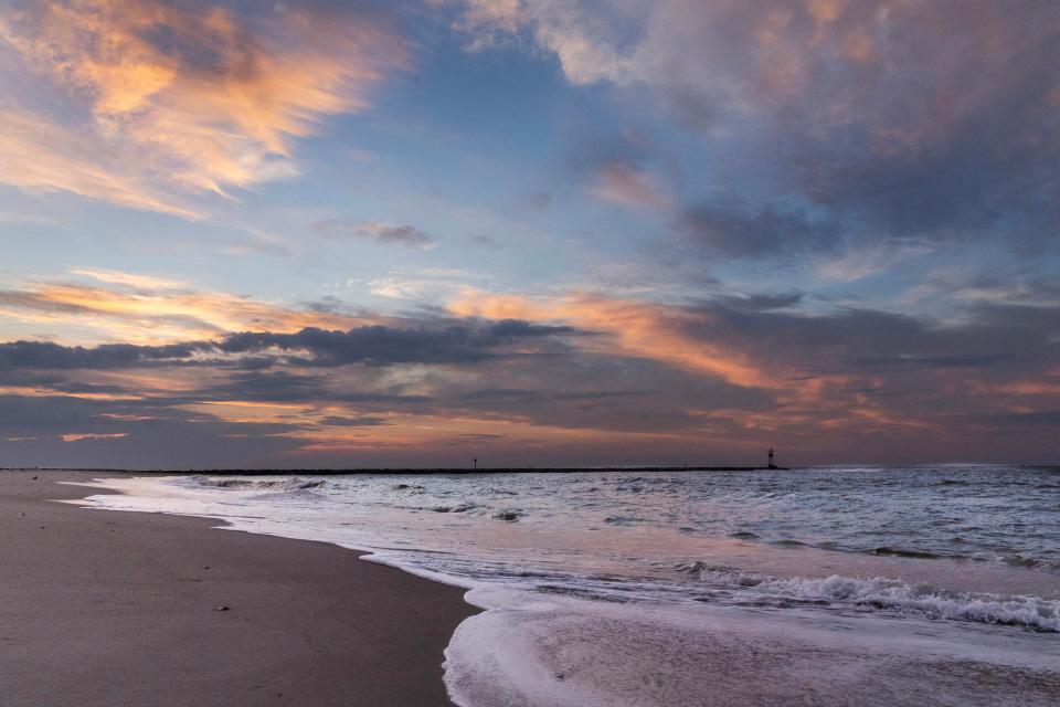 A cloudy, hazy sky as rain clouds and sunshine battle for dominance as summer unfolds at Barnegat Light. 