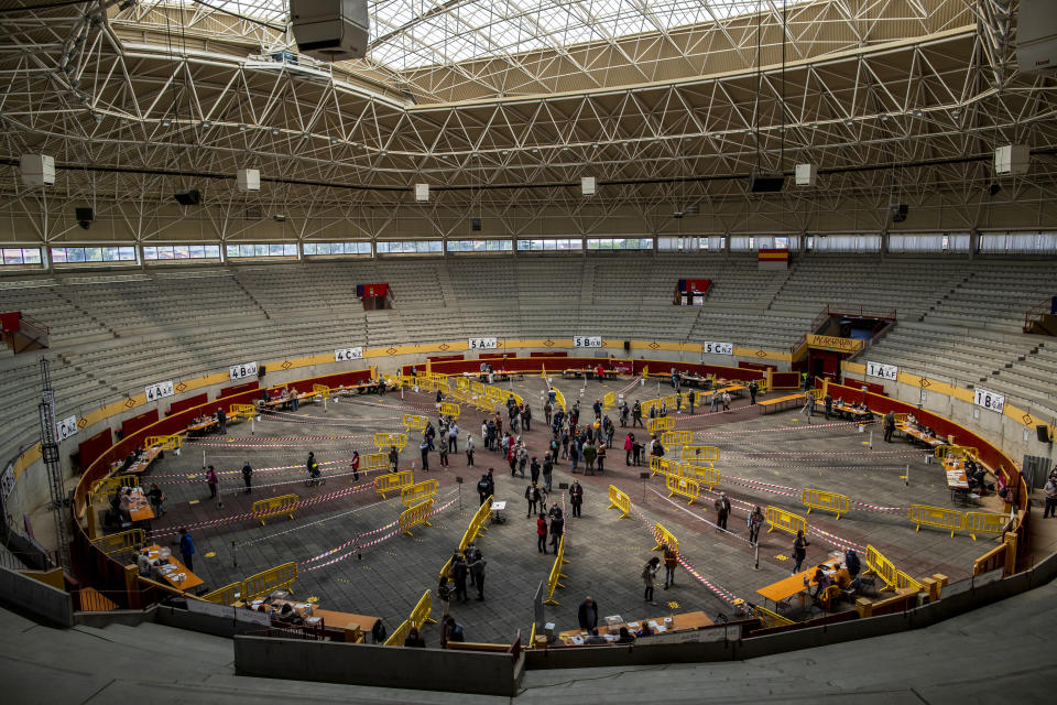 People queue to cast their votes during the regional election at the bullring in Moralzarzal, Spain, Tuesday, May 4, 2021. Over 5 million Madrid residents are voting for a new regional assembly in an election that tests the depths of resistance to lockdown measures and the divide between left and right-wing parties. (AP Photo/Manu Fernandez)