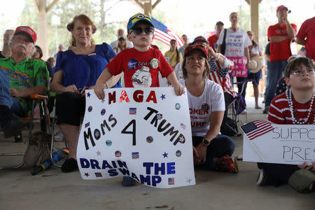 Supporters of U.S. President Donald Trump listen to a speaker as a boy holds a sign during a rally in Mandeville, Louisiana U.S., February 27, 2017. REUTERS/Shannon Stapleton